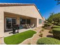 Cozy backyard with a covered patio, artificial turf area, and low-maintenance desert landscaping at 2473 Luminous Stars St, Henderson, NV 89044