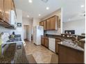 Functional kitchen with stainless steel appliances, granite countertops, and wood cabinetry at 2473 Luminous Stars St, Henderson, NV 89044