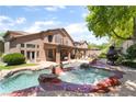 An entertainer's backyard with a custom pool, spa, covered patio, and mature landscaping at 259 Rockwell Springs Ct, Henderson, NV 89012