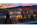 Stunning two-story home at dusk with warm exterior lighting and a charming front porch in a quiet neighborhood at 2714 Frabiele St, Henderson, NV 89044