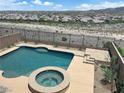Relaxing backyard oasis with a sparkling pool and spa, surrounded by lush landscaping and scenic mountain views at 2714 Frabiele St, Henderson, NV 89044