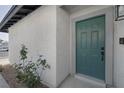 Close up of the bright teal front door with dark hardware and decorative trim at 59 N Christy Ln, Las Vegas, NV 89110