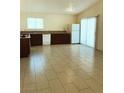 Open kitchen area with tiled flooring, wooden cabinets, and a white refrigerator at 6196 W University Ave, Las Vegas, NV 89103