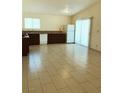 Kitchen features tile floor, white appliances, and wooden cabinetry for ample storage at 6196 W University Ave, Las Vegas, NV 89103