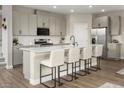 Modern kitchen with stainless steel appliances and an island with barstool seating at 7394 Daly Grove St, Las Vegas, NV 89113