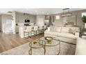 Open living space featuring a kitchen island, dining table, and sofas at 7394 Daly Grove St, Las Vegas, NV 89113