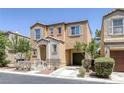 Two-story home showcasing an inviting entry and attached garage, complemented by manicured landscaping, exuding curb appeal at 9100 Hombard Ave, Las Vegas, NV 89148