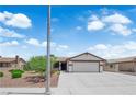 Single-story home with a two-car garage and a well-manicured front yard under a partly cloudy sky at 1105 Winwood St, Las Vegas, NV 89108
