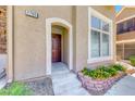 Attractive front entryway with an arched porch, decorative stone accents, and colorful flowerbed at 2766 Red Vista Ct, Henderson, NV 89074