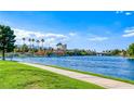Scenic view of the community lake with lush greenery, palm trees, and bridge at 3125 N Buffalo Dr # 1133, Las Vegas, NV 89128