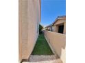 A side yard featuring green turf and rock landscaping at 39 Belle La Blanc Ave, Las Vegas, NV 89123