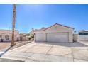 Single-story home featuring an attached two-car garage, desert landscaping, and a red-tiled roof at 4010 Hemphill St, North Las Vegas, NV 89032