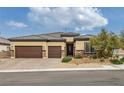 Charming home featuring a three-car garage, stone accents, and desert landscaping, offering curb appeal at 5234 Savannah Rose St, Las Vegas, NV 89149
