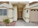 Covered entryway with double doors, stone landscaping, and a brick paved driveway at 525 Sun Mountain Ave, North Las Vegas, NV 89031