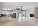 Open-concept living room features neutral walls, tile flooring, fireplace, and a modern light fixture at 525 Sun Mountain Ave, North Las Vegas, NV 89031