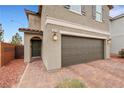 Home exterior with a brick driveway leading to a two-car garage and a charming entrance at 6619 Frosted Harvest Ave, Las Vegas, NV 89108