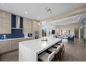 Open kitchen featuring a large island with seating, modern stainless steel appliances, and pendant lighting at 6804 Regency Stone Way, Las Vegas, NV 89148