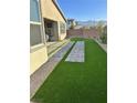 A well-manicured backyard with artificial grass, pavers, rocks, and a brick perimeter wall for privacy at 6834 Compass St, North Las Vegas, NV 89084
