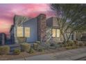 This is an attractive single-story home with desert landscaping and a modern stone chimney accent at 6834 Compass St, North Las Vegas, NV 89084