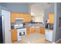 Bright eat-in kitchen featuring wooden cabinetry, stainless-steel appliances, and granite countertops at 7340 Alpine Ridge St, Las Vegas, NV 89131