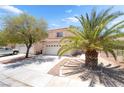 Charming two-story home featuring a tile roof, two-car garage, and palm trees at 7459 Aurora Glow St, Las Vegas, NV 89139