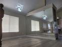 Large living area offering lots of natural light from windows, wood floors, and modern light fixture at 9556 Ancala Hollow Ct, Las Vegas, NV 89148