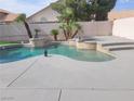 Backyard pool with spa, tile accents, palms, and concrete decking create a private oasis at 9556 Ancala Hollow Ct, Las Vegas, NV 89148