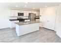 Modern kitchen with stainless steel appliances, white cabinets, gray countertops, and a center island at 10434 Luna Mezzo St Ave # Lot 188, Las Vegas, NV 89141
