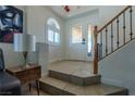 Bright foyer with tile flooring, staircase, a decorative front door and a side window at 10949 Fintry Hills St, Las Vegas, NV 89141