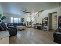 Open-concept living room featuring hardwood floors, a staircase, and an abundance of natural light at 10949 Fintry Hills St, Las Vegas, NV 89141