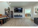 Bright living room featuring hardwood floors, a large television, and an open floor plan at 10949 Fintry Hills St, Las Vegas, NV 89141