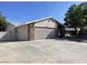 This single-story home features a two-car garage, and mature landscaping in a well-kept yard at 1441 Bronco Rd, Boulder City, NV 89005