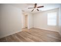 Bright, airy bedroom with wood-look floors, a ceiling fan, a double door closet, and natural light from the window at 1617 Meadow Bluffs Ave, Henderson, NV 89014