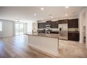 Open-concept kitchen featuring a granite island, stainless steel appliances, and dark wood cabinetry with sleek hardware at 1617 Meadow Bluffs Ave, Henderson, NV 89014