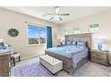 Comfortable bedroom with a large window, ceiling fan, and mountain views at 163 Caraset Ln, Henderson, NV 89011