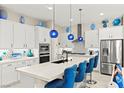 Modern kitchen features stainless appliances, a center island with seating, and white cabinetry at 163 Caraset Ln, Henderson, NV 89011