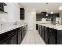 Modern kitchen with dark cabinetry, stainless appliances, and a white tile floor at 1633 Dornie Ave, North Las Vegas, NV 89084
