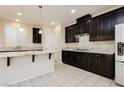 Modern kitchen featuring dark cabinets, granite countertops, and stainless appliances at 1633 Dornie Ave, North Las Vegas, NV 89084