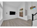 Bright living room with wood floors, high ceilings, and modern light fixtures at 21 Rue De Degas, Henderson, NV 89074