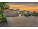 Charming home displaying a spacious three-car garage and brick driveway, adding curb appeal to the property at 2997 Via Meridiana, Henderson, NV 89052