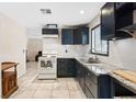Updated kitchen with granite countertops, subway tile backsplash, black cabinets, and tile floors at 3715 Tabor Ave, North Las Vegas, NV 89030