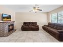 Cozy living room features a brick fireplace, ceiling fan, tile flooring, and comfortable seating at 3715 Tabor Ave, North Las Vegas, NV 89030