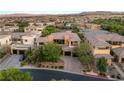 Modern home with tile roof features manicured landscaping, a three-car garage, and a paved driveway at 38 Moonfire Dr, Las Vegas, NV 89135