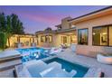 Outdoor oasis with a sparkling pool, spa, and covered outdoor kitchen and entertaining area at 38 Moonfire Dr, Las Vegas, NV 89135