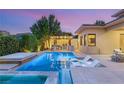 Inviting outdoor pool and spa area with stylish lounge chairs and an outdoor kitchen at 38 Moonfire Dr, Las Vegas, NV 89135
