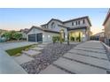 Stunning two-story home featuring a tile roof, desert landscaping, and a modern driveway design at 387 Hoskins Ct, Henderson, NV 89012
