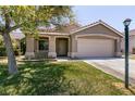 Inviting home with a manicured lawn, two-car garage, and attractive desert landscaping at 4825 White Aspen Ave, Las Vegas, NV 89130