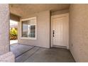 Welcoming front porch with neutral stucco walls, a window, and a secure front door at 4825 White Aspen Ave, Las Vegas, NV 89130
