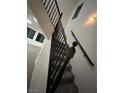 Classic staircase with dark wood railings, carpeted steps, and a charming window accenting the ascent at 6412 Point Break St, North Las Vegas, NV 89084