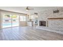 Bright living room showcasing a brick fireplace and sliding glass doors that lead to the pool area at 6848 Groveview Ln, Las Vegas, NV 89103